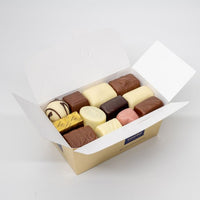 Assortment of Leonidas Brighton fresh butter cream chocolates in an open white gift box.